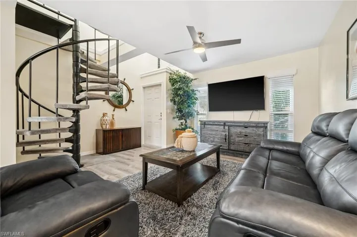 Living room with view to front door and stair to the upstairs.