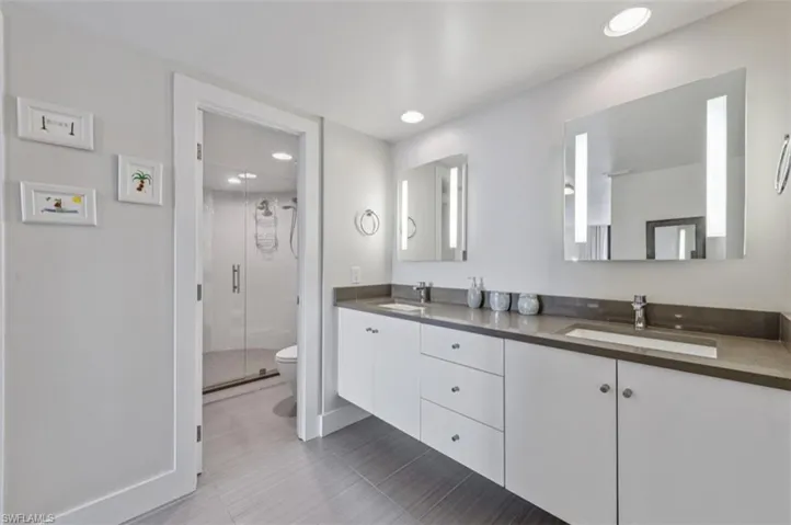 Full Bathroom featuring double vanity, a stall shower, and recessed lighting
