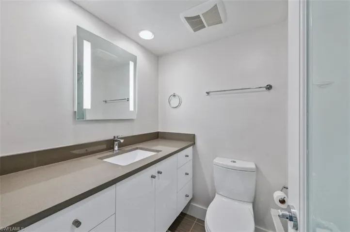 Full Bathroom with light up vanity and glass shower door