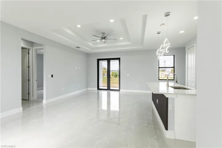Spare room featuring ceiling fan, a tray ceiling, and sink
