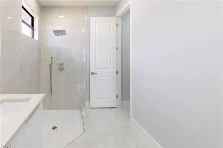 Bathroom with vanity and tiled shower