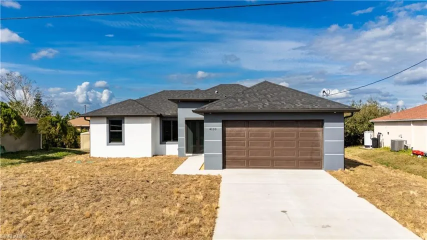 View of front of house with a garage, a front lawn, and central air condition unit