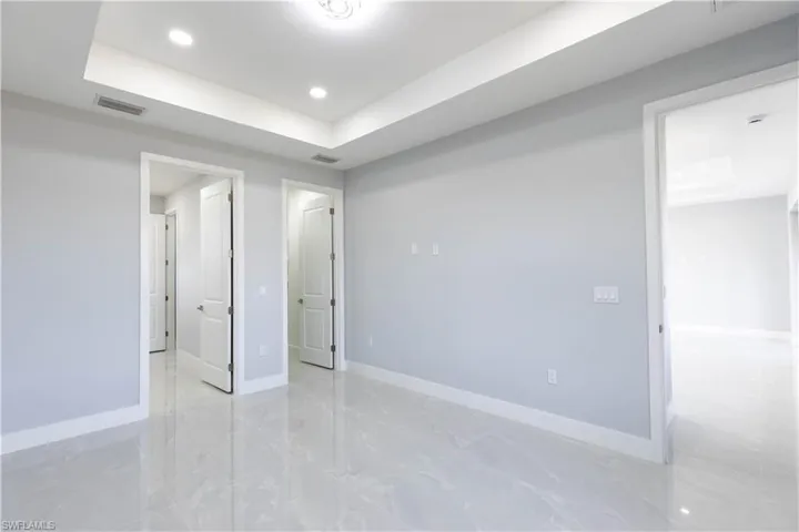 Unfurnished bedroom featuring a tray ceiling