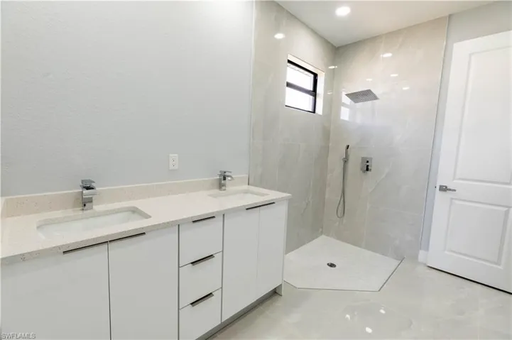 Bathroom with vanity and tiled shower