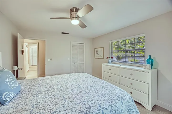 Bedroom featuring ceiling fan, a closet, and multiple windows