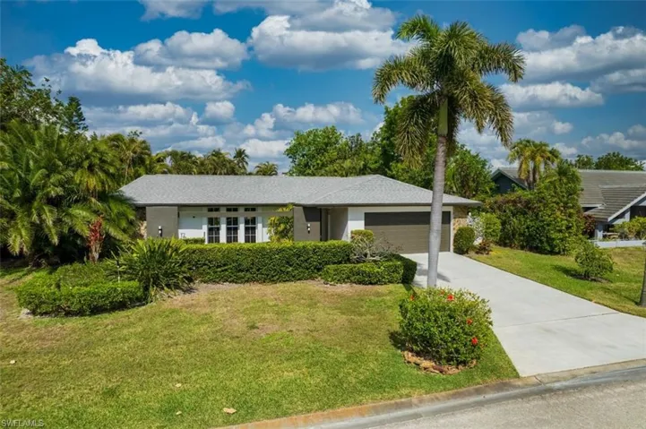 Single story home with a garage and a front lawn