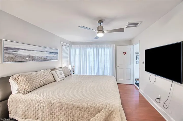 Bedroom with ceiling fan and dark hardwood / wood-style flooring