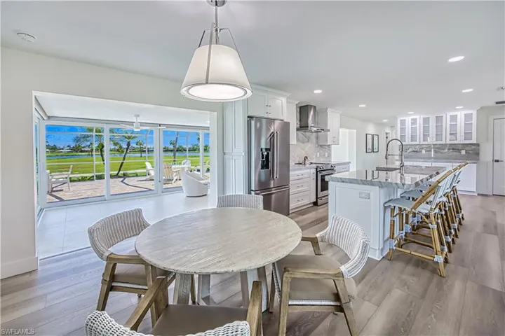 Dining room with light wood-style floors, recessed lighting, and a sunroom