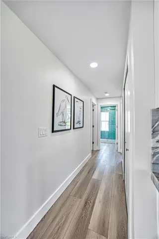 Hall with light wood-style flooring and recessed lighting