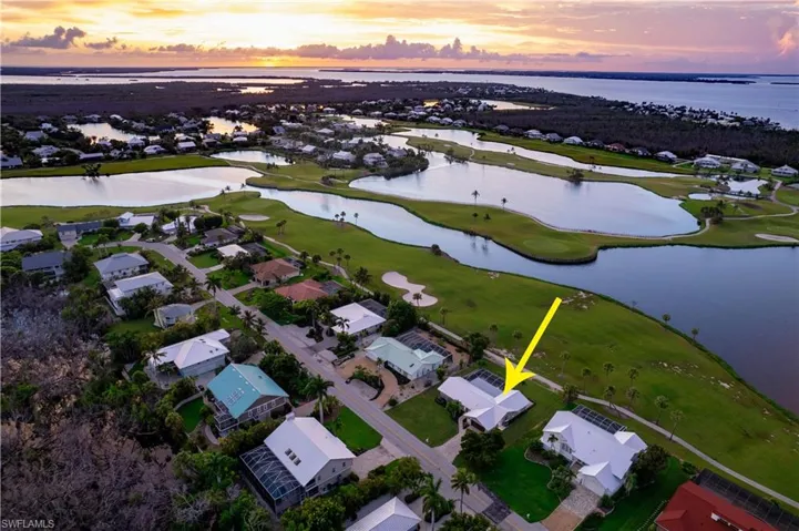 Aerial view of property's location featuring a nearby body of water and nearby suburban area
