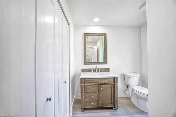 Half bath featuring vanity, light wood-style floors, and recessed lighting
