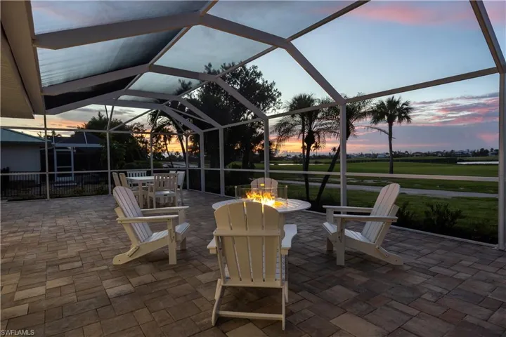 View of patio / terrace featuring glass enclosure, a fire pit, and a sunroom