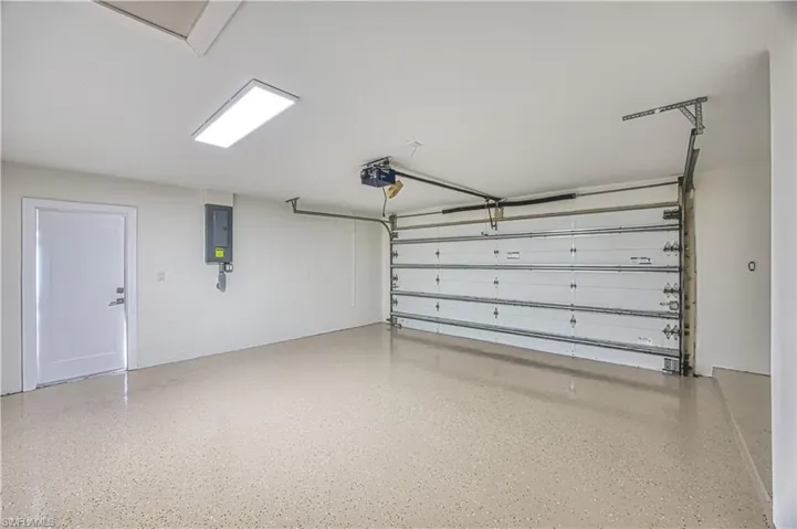 Garage featuring electric panel and a garage door opener