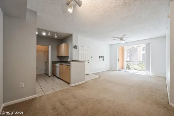 Kitchen with ceiling fan, rail lighting, light colored carpet, and light brown cabinets