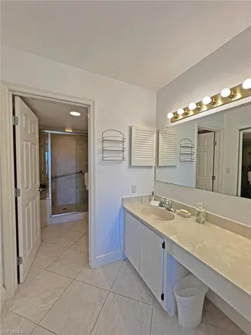 Bathroom with vanity, a shower stall, and light tile patterned floors