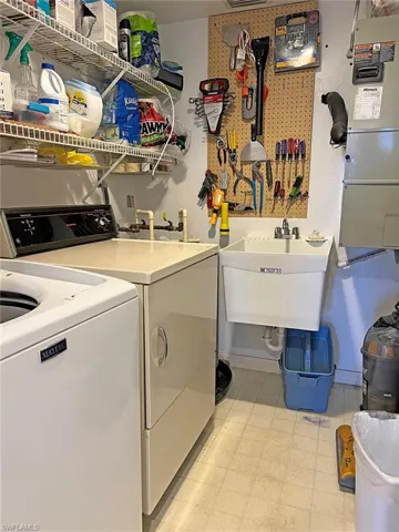 Laundry area featuring light floors, separate washer and dryer, and heating unit