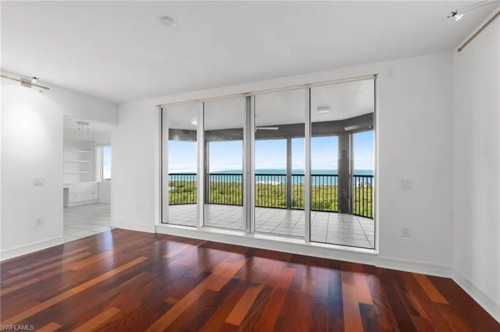 Empty room with built in features, hardwood / wood-style flooring, and a water view