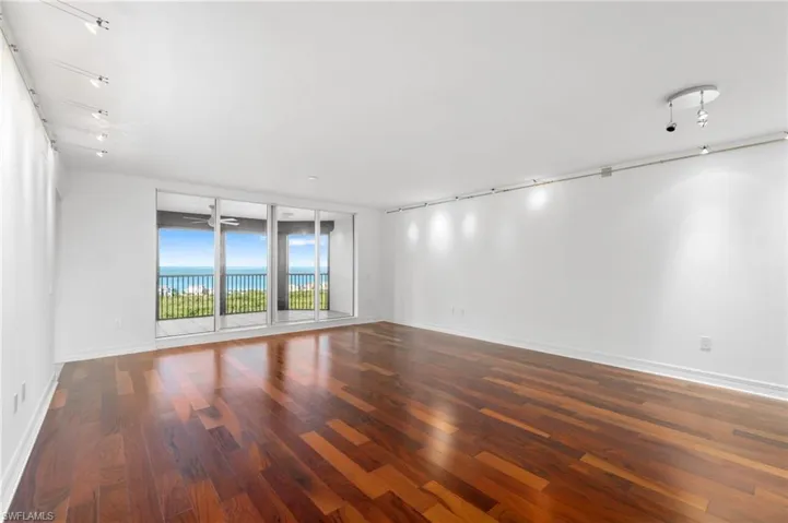 Unfurnished room featuring a water view and dark hardwood / wood-style floors