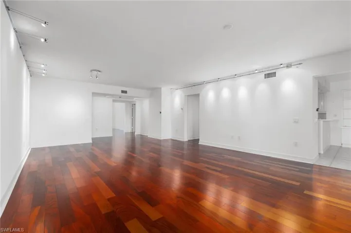 Empty room featuring dark hardwood / wood-style flooring