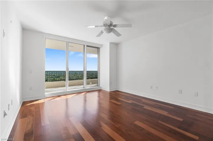 Empty room with ceiling fan and wood-type flooring