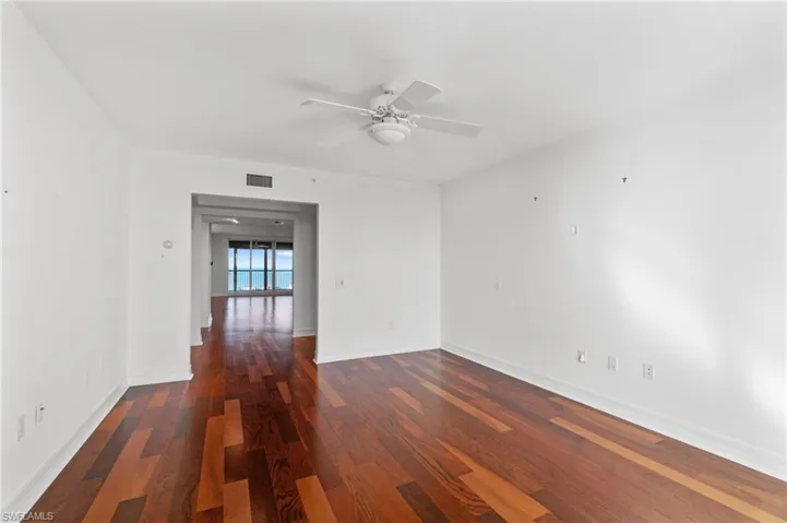 Spare room with dark wood-type flooring and ceiling fan