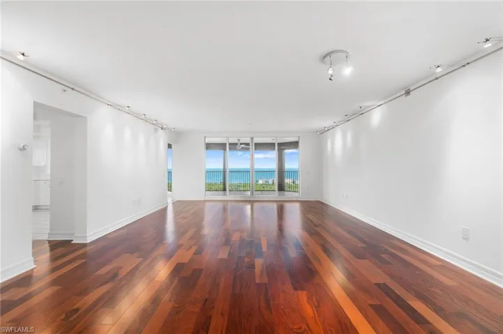 Spare room with expansive windows and dark hardwood / wood-style flooring