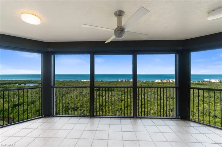 Unfurnished sunroom featuring a water view and ceiling fan
