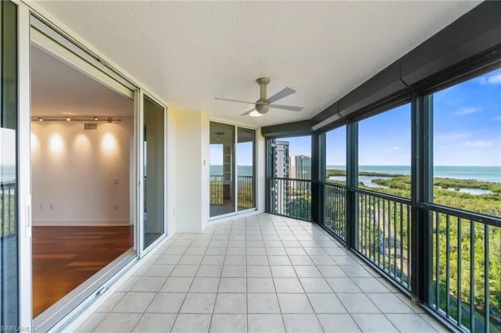 Unfurnished sunroom featuring a water view, rail lighting, and ceiling fan