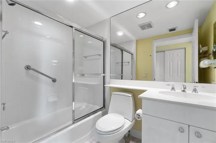 Full bathroom with vanity, toilet, and shower / bath combination with glass door