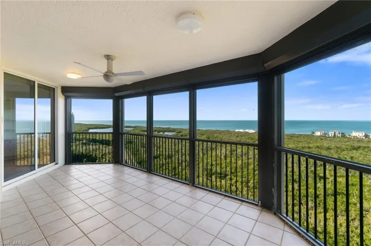 Unfurnished sunroom featuring ceiling fan, a water view, and plenty of natural light