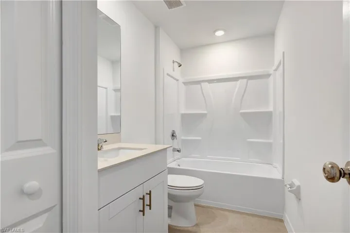 Bathroom featuring a white vanity with bronze hardware, a light-colored countertop, and an integrated sink