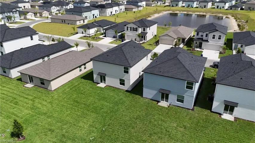 Aerial perspective showcasing multiple residential properties with varied exterior finishes and dark shingle roofing