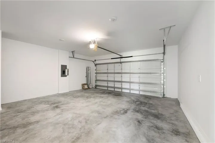 Spacious garage featuring a concrete floor, painted white walls, and an overhead garage door