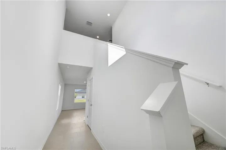 Open-concept entryway featuring a two-story ceiling, recessed lighting, and a neutral color palette