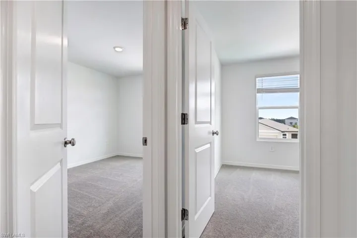 Two rooms featuring light gray carpeting, white walls, white trim, and white doors