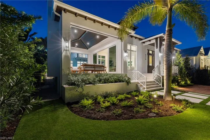 Covered lanai with gas grill, fireplace, refrigerator, screens, and shades.