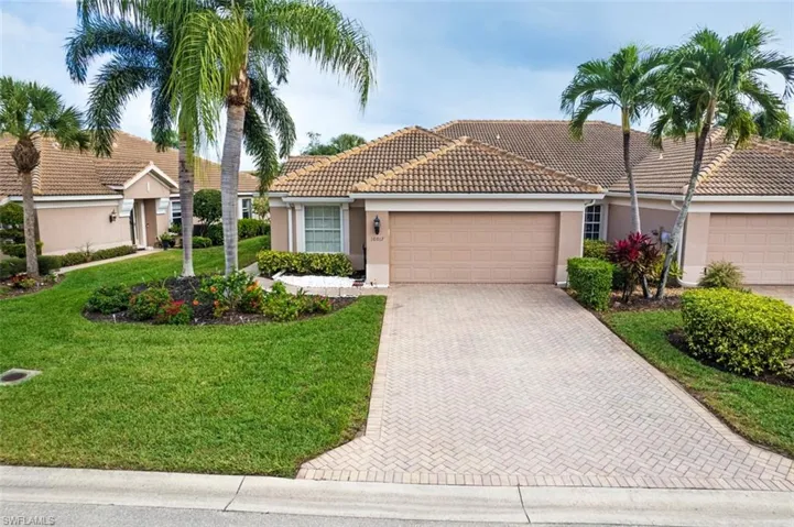 View of front facade featuring stucco siding, a front yard, decorative driveway, a garage, and a tiled roof