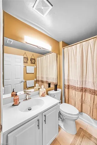 Full bath featuring vanity and light tile patterned floors