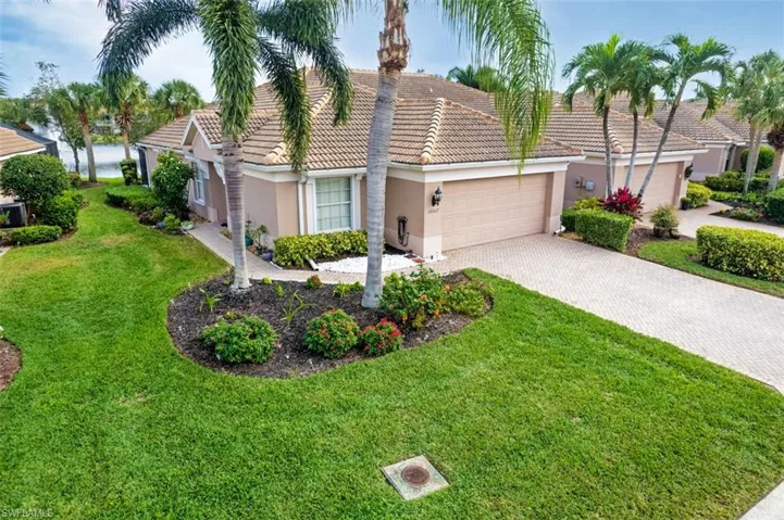 Mediterranean / spanish house featuring stucco siding, a garage, a front yard, decorative driveway, and a tiled roof