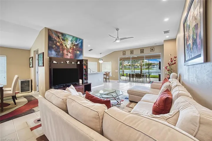Living room with tile patterned flooring, recessed lighting, vaulted ceiling, and ceiling fan