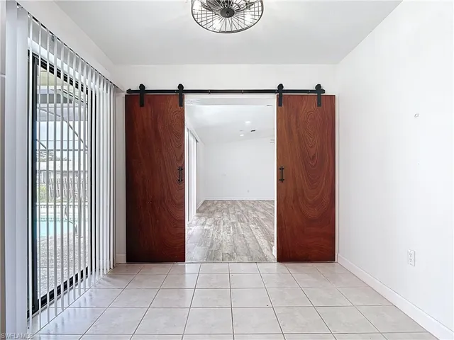 Unfurnished room featuring a barn door and light tile patterned flooring