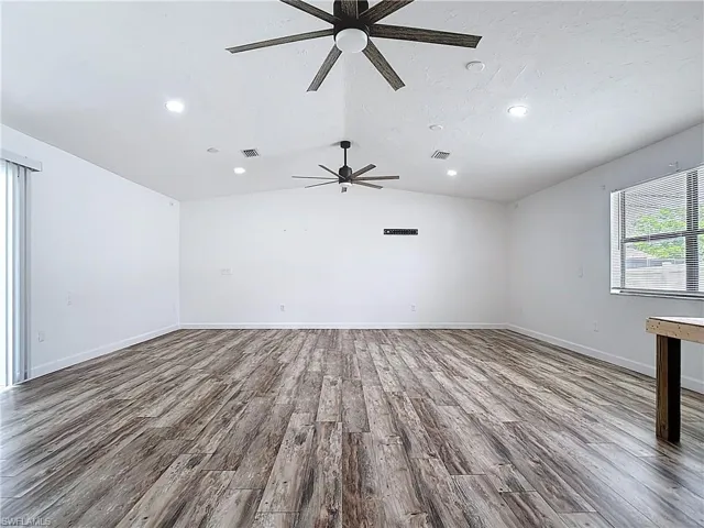 Empty room featuring ceiling fan, recessed lighting, wood finished floors, and lofted ceiling