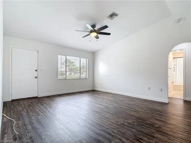 arched walkways, dark wood finished floors, and a smoke detector