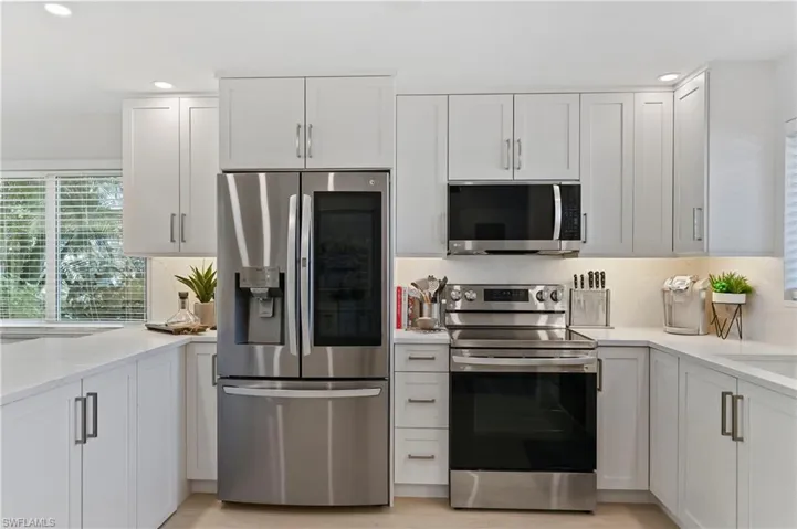 Kitchen featuring stainless steel appliances, recessed lighting, white cabinetry, and a sink