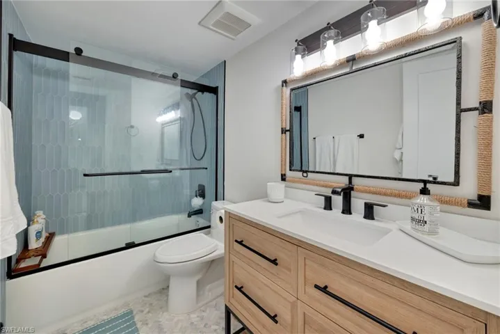 Full bathroom with shower / bath combination with glass door and vanity