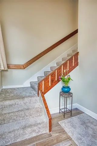 Staircase featuring baseboards and wood finished floors