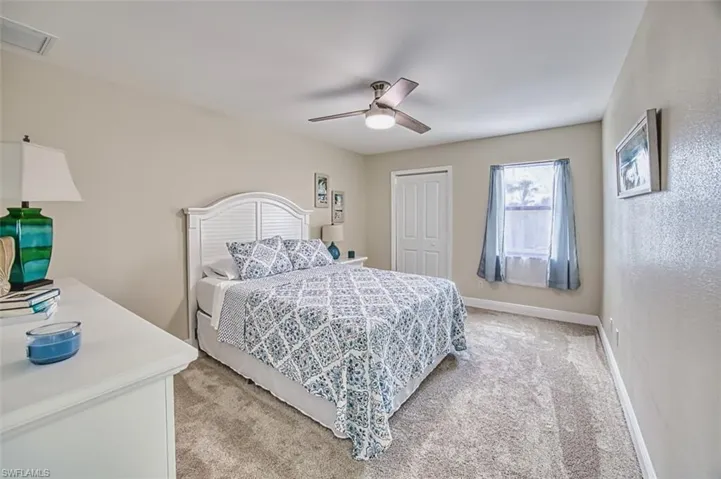 Bedroom featuring light carpet, a closet, ceiling fan, and baseboards