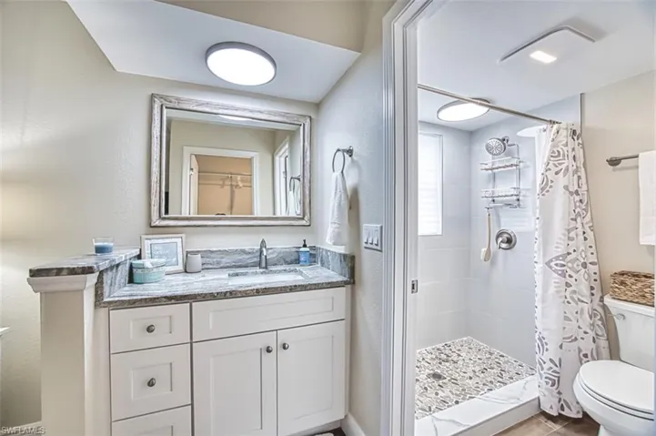 Bathroom with a stall shower, toilet, and vanity