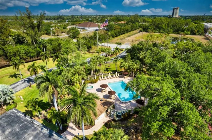 Drone / aerial view of a pool area and a tree filled landscape