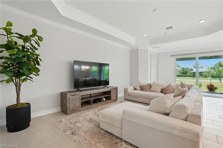 Kitchen with appliances with stainless steel finishes, arched walkways, backsplash, a kitchen breakfast bar, and a center island with sink